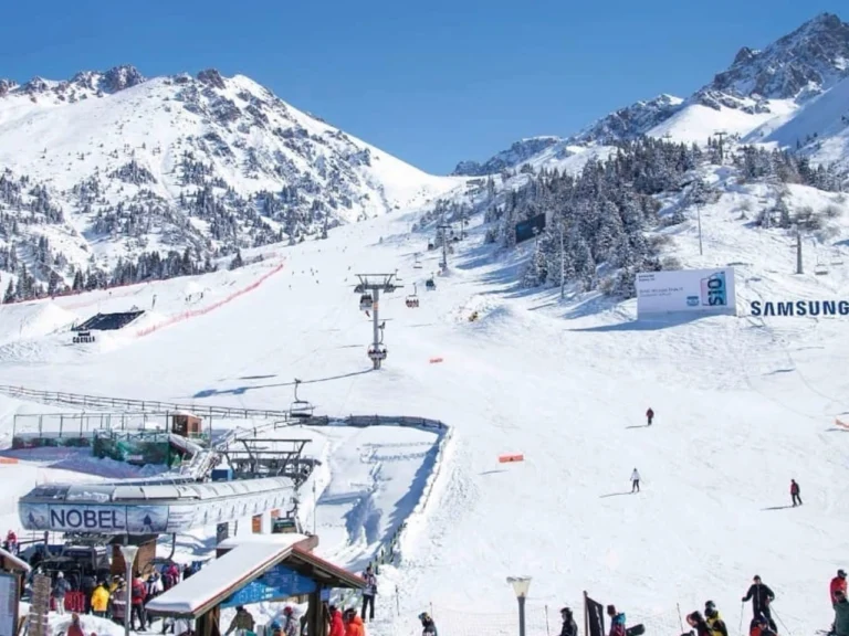 Main ski area and base station at Shymbulak with skiers on the slopes
