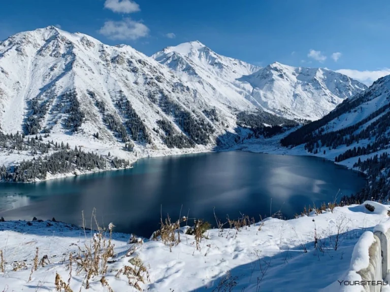 Snow-covered Big Almaty Lake and dramatic winter mountain scenery in Kazakhstan.