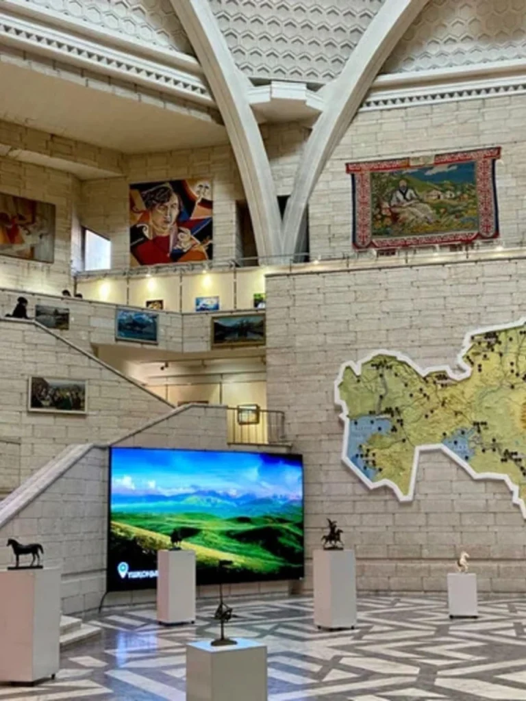 Interior hall of the Central State Museum of Kazakhstan with exhibits, large Kazakhstan map and digital display