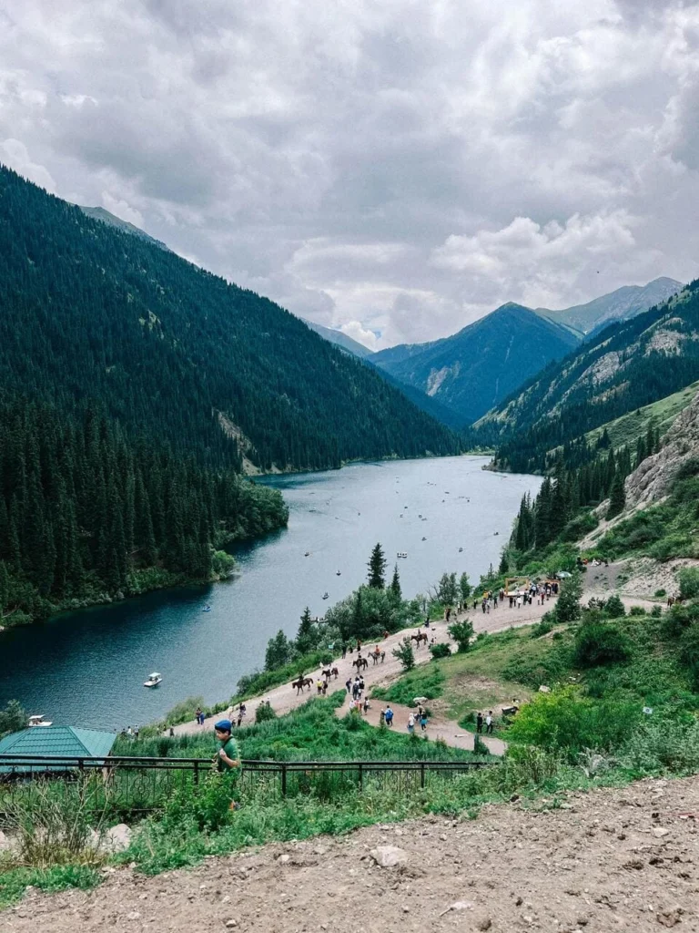Drone view of Issyk Lake’s turquoise water and surrounding pine forests in the Almaty region, Kazakhstan.