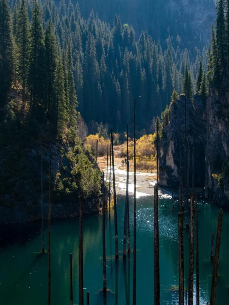 Stunning view of Kaindy Lake with submerged spruce trees and turquoise water near Almaty, Kazakhstan.