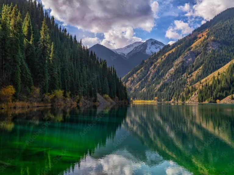 emerald green water of kolsay lake with mountain reflection