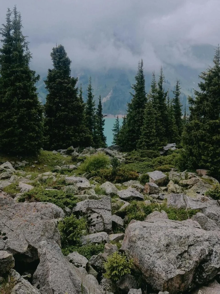 Peaceful morning at Issyk Lake with calm water and mist over the mountain peaks, Almaty, Kazakhstan.